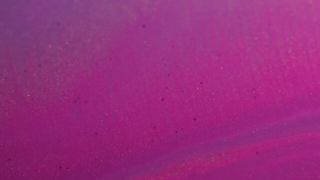 Paint stream. Glitter background. Defocused pink neon color liquid shiny texture droplets floating on creative abstraction.