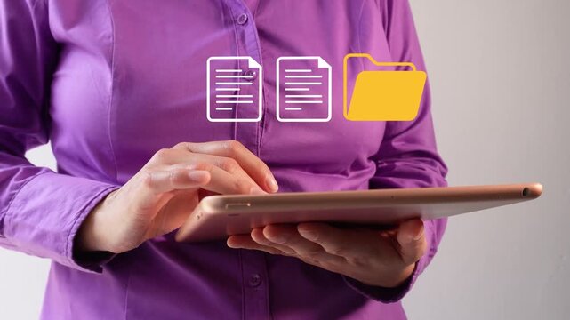 Close-up of a businesswoman interacting with her tablet with an animated icon of a folder and a couple of documents. File management.