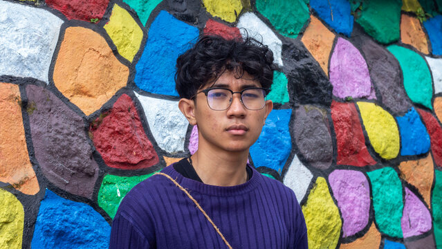 a young man wearing glasses with colorfull backgorund at "colorfull" Village Malang