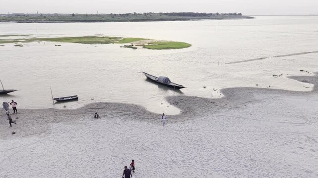 Aerial footage showing visitors exploring a sandy riverbank and traditional boats at the Padma-Gorai River Confluence in Kushtia, Bangladesh, filmed on June 27, 2026.