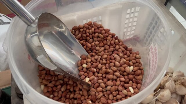 Close Up of Raw Peeled Peanuts with Metal Scoop in Plastic Basket