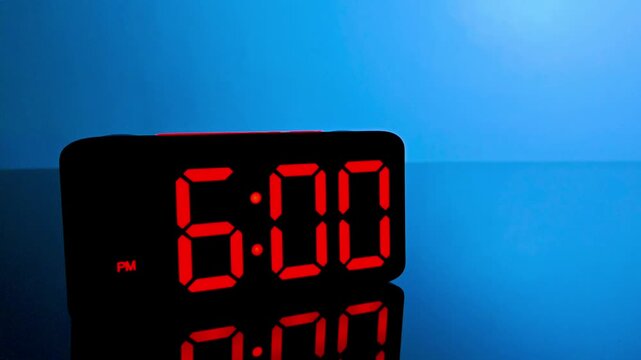 Digital alarm clock changing from 5:59 pm to 6:00 pm with red led display