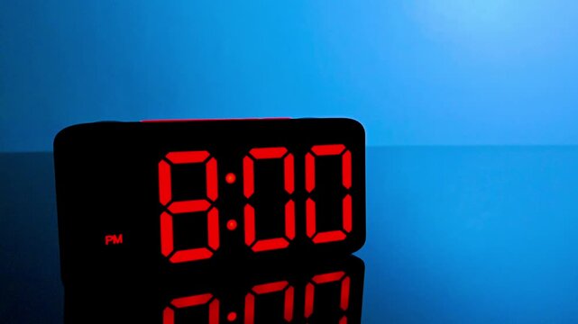 Digital alarm clock changing from 7:59 pm to 8:00 pm with red led display