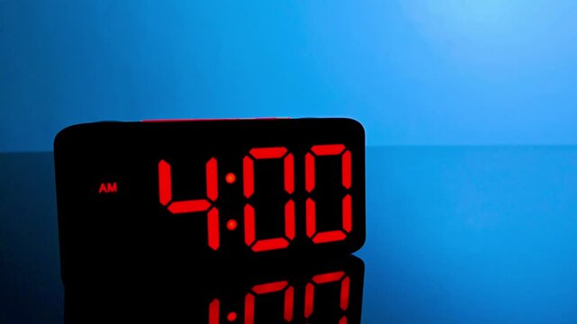 Digital alarm clock changing from 3:59 am to 4:00 am with red led display