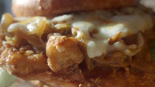 Enjoying a tasty burger with chicken and cheese