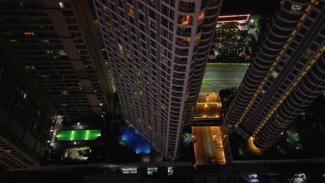 Slow tracking drone shot across the Twin Oaks property highlighting the building footprint, nearby road access, and surrounding mixed-use developments in Metro Manila Philippines.