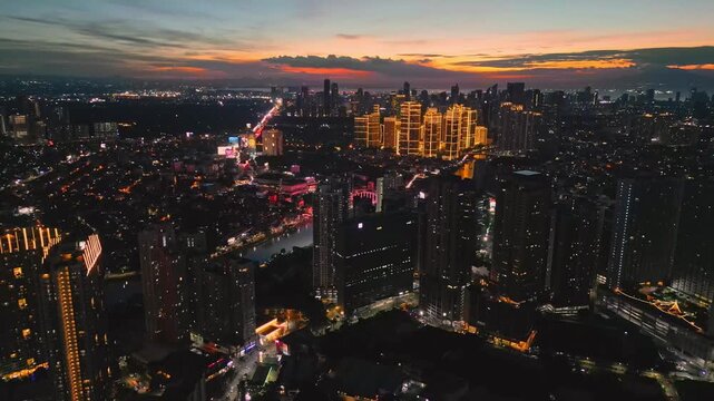 Top view aerial shot of Rockwell and Pasig River in Makati Metro Manila Philippines revealing the bridge, riverbank layout, and clustered high rise buildings at sunset.
