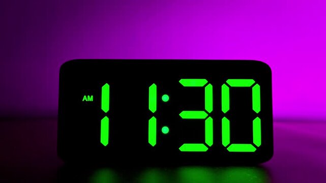Glowing green digital clock changing from 11:29 to 11:30 AM on neon purple background