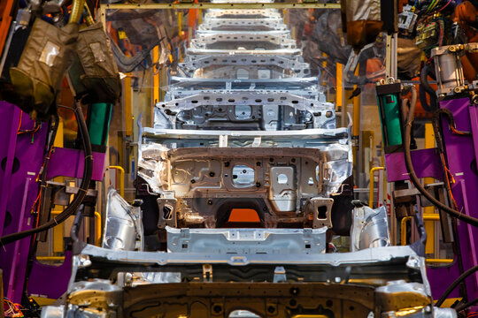Robotic arms are welding points on the car body on an automated production line.