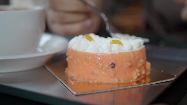 small mango mousse cake topped with whipped cream and yellow fruit topping