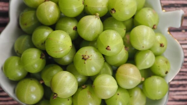 These green fruits are Indian gooseberries, also commonly known as amla or amalaki