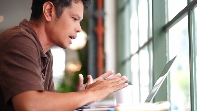 Asian Businessman Having Online Video Conference While Holding Business Planning Chart for Strategy Analysis