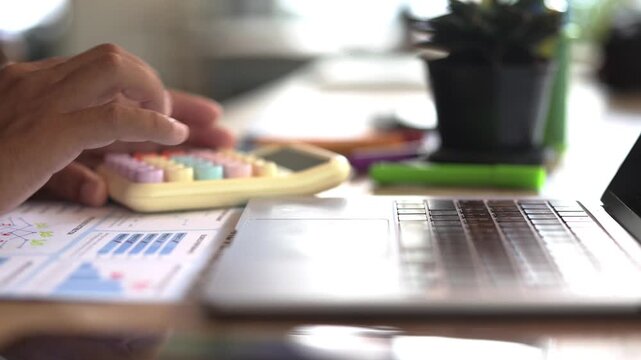 Man Using Laptop and Calculator for Financial Planning, Accounting Work, Business Calculation, Office Management and Money Budgeting Concept