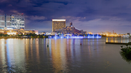 Obraz premium (Photo) Odaiba Waterfront Nightscape with Illuminated Fountains and City Reflections Tokyo Japan