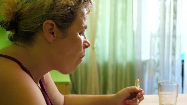 Woman eating a homemade stuffed cabbage roll, taking a bite from a fork and enjoying a homemade lunch in a calm home setting.