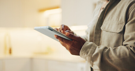 Ebook, search and hands in house with tablet, online library or scrolling on storytelling platform. Digital, space and man in home with tech, virtual browse or portable reading on literature site. © peopleimages.com