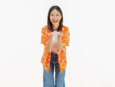 Cheerful young Asian woman in colorful summer floral shirt presenting empty copy space with open palm isolated on white studio background.