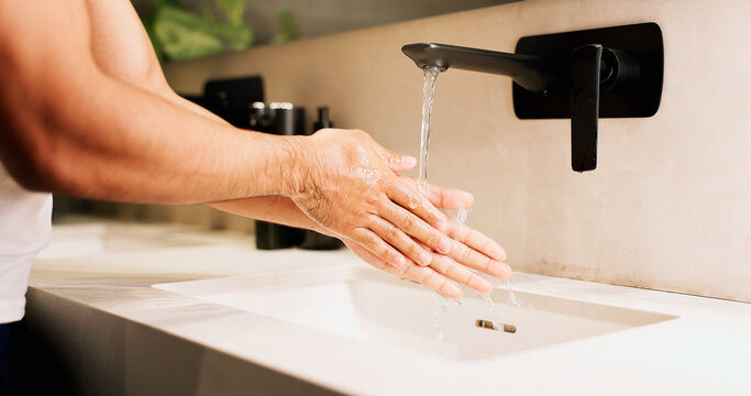 Basin, washing hands and water with person in bathroom for hygiene, skincare or wellness. Cleaning, disinfection and tap with man at apartment sink to remove bacteria, dirt or germs for maintenance