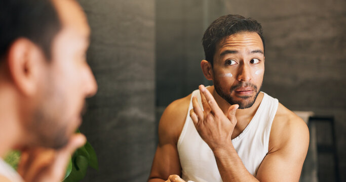 Lotion, mirror and skincare with man in bathroom of home for morning hydration routine. Daily beauty, moisturizer and reflection with person in apartment to apply cream for antiaging treatment