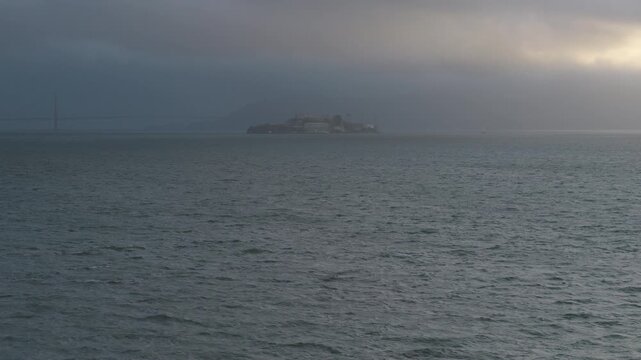 Cinematic aerial shot over choppy ocean with view of alcatraz island in storm