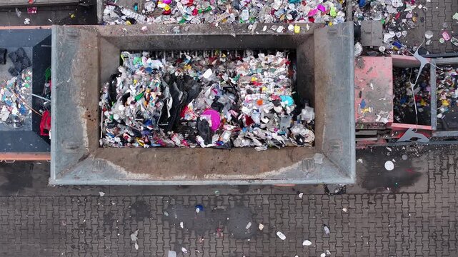 Plastic waste processing at recycling facility in operation with trucks