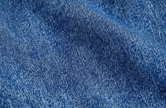 close-up of blue denim fabric with visible twill weave and soft folds, textured casual textile evoking comfort