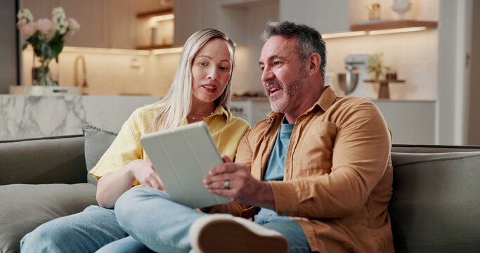 Couple, relax and conversation in home with tablet, browsing social media or digital app for news. Married, mature man and woman on sofa with tech, reading article or discussion for bonding together.