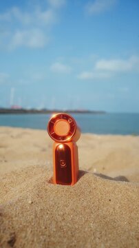 Portable handy fan on the beach and the background is the sea and the sky in summer.