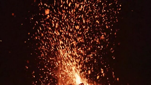 Fiery Display of Sparks Rising from Fire, Floating Upwards in the Black Night, Orange and Red Glowing Particles