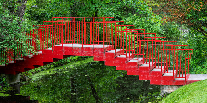 Red bridge spanning small canal in Dow gardens, Michigan