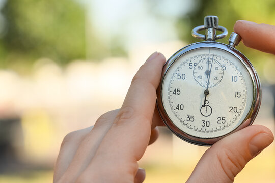 Hand holding a stopwatch outdoors