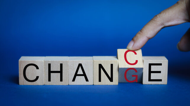 Business change management concept with a hand replacing a wooden block to complete the word CHANGE, symbolizing transformation, innovation, adaptation, leadership, continuous improvement