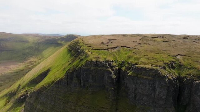 Cinematic drone shot of Ben Bulben table mountain in Sligo, Ireland. Famous flat-topped landmark with green countryside and majestic rock cliffs.