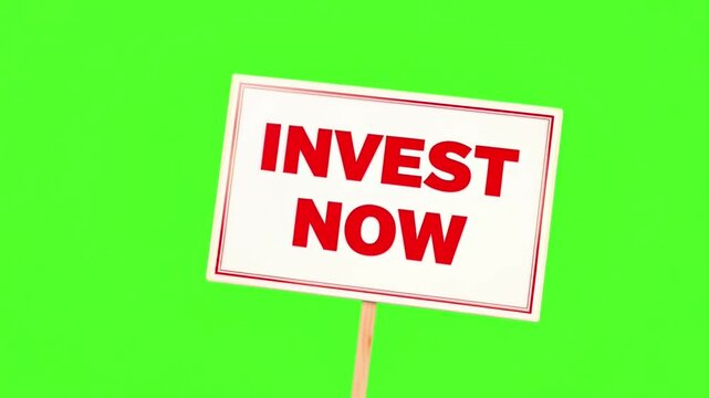 Invest Now text on a white placard isolated on a green screen background