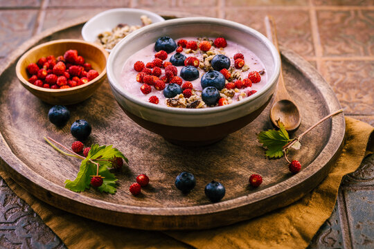 Healthy breakfast yogurt bowl with fresh blueberries and wild strawberries