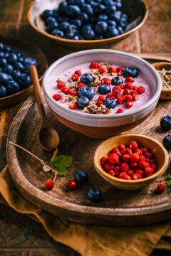Healthy breakfast yogurt bowl with fresh blueberries and wild strawberries