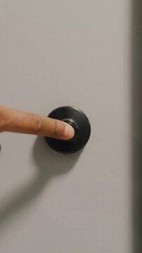 Close up finger pressing apartment doorbell for contactless delivery service