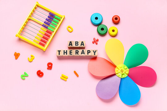 Colorful abacus and toys with wooden blocks spelling ABA therapy