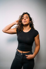 Confident young woman posing with hand in hair