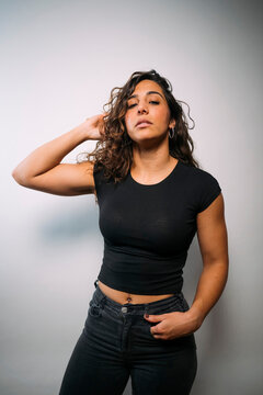 Confident young woman posing with hand in hair