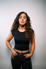 Young adult woman standing with hands in pockets