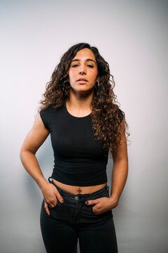Young adult woman standing with hands in pockets