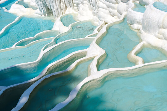 Blue mineral pools on white limestone terraces