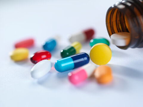 A variety of drugs falling from a medicine bottle.