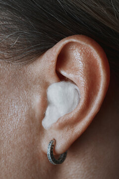 Close up of a human ear plugged with cotton wool to block fake news
