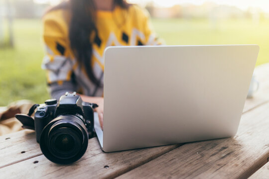 Businesswoman with camera working on laptop outdoors