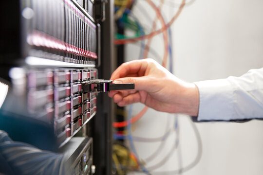 Close-up of male engineer examining computer equipment in data center