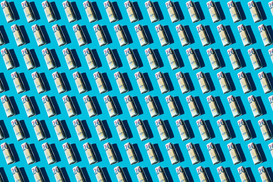 Twenty euro rolled banknotes pattern on a blue background