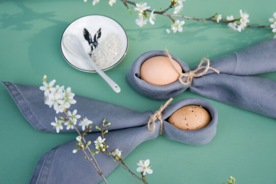 Easter decoration, Twigs of sloe, napkins with Easter eggs, folded as rabbit ears