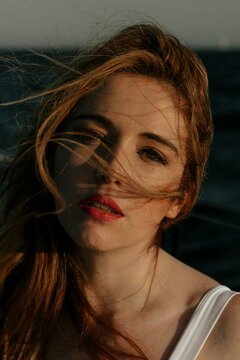 Portrait of redhead looking at camera with wind blowing hair